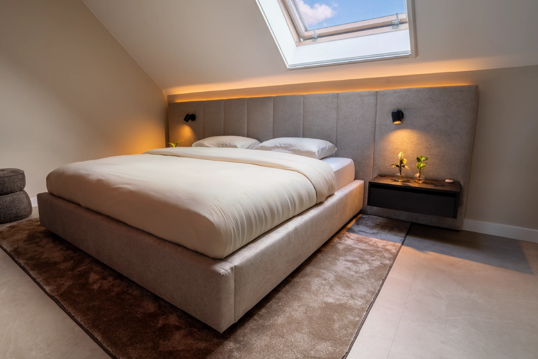 Bed met hoofdpaneel op maat onder een schuin dak