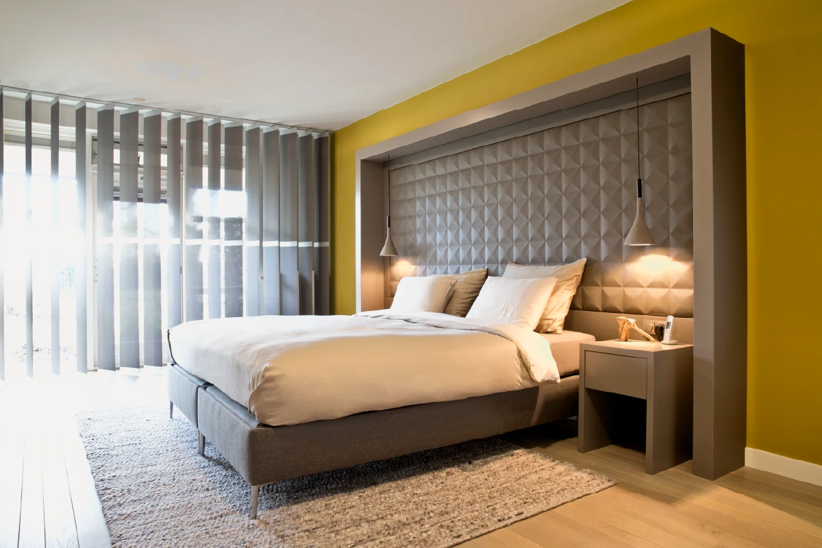 Boxspring met kamerhoog hoofdpaneel en hangende lampen