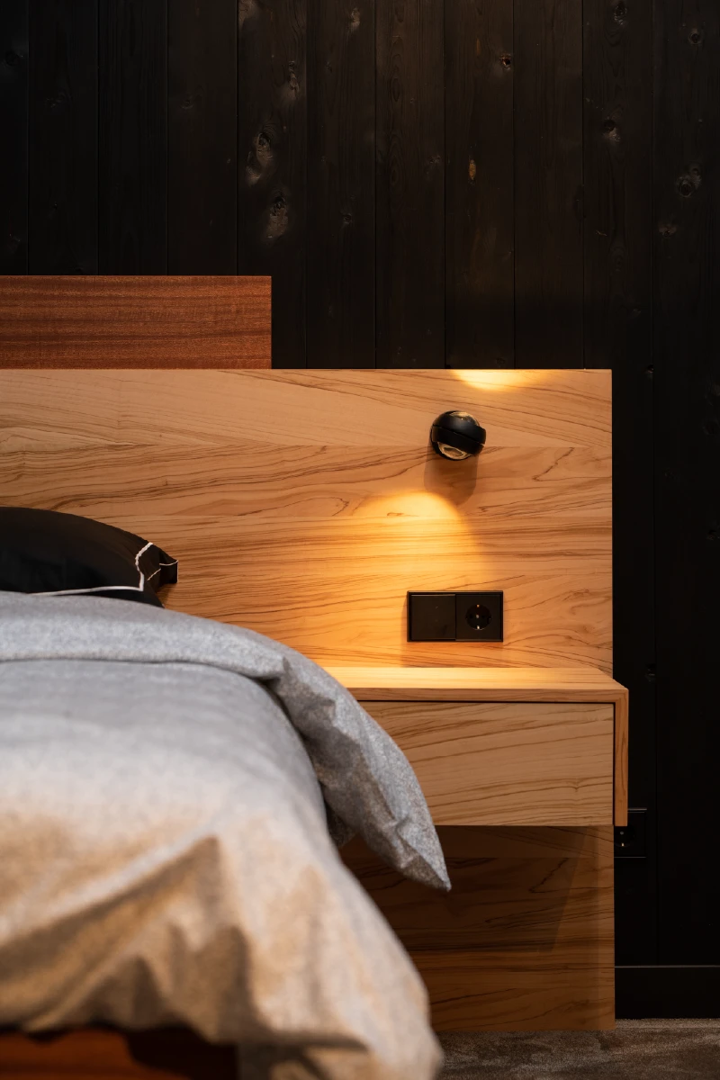 Olijfhouten nachtkastje naast het bed