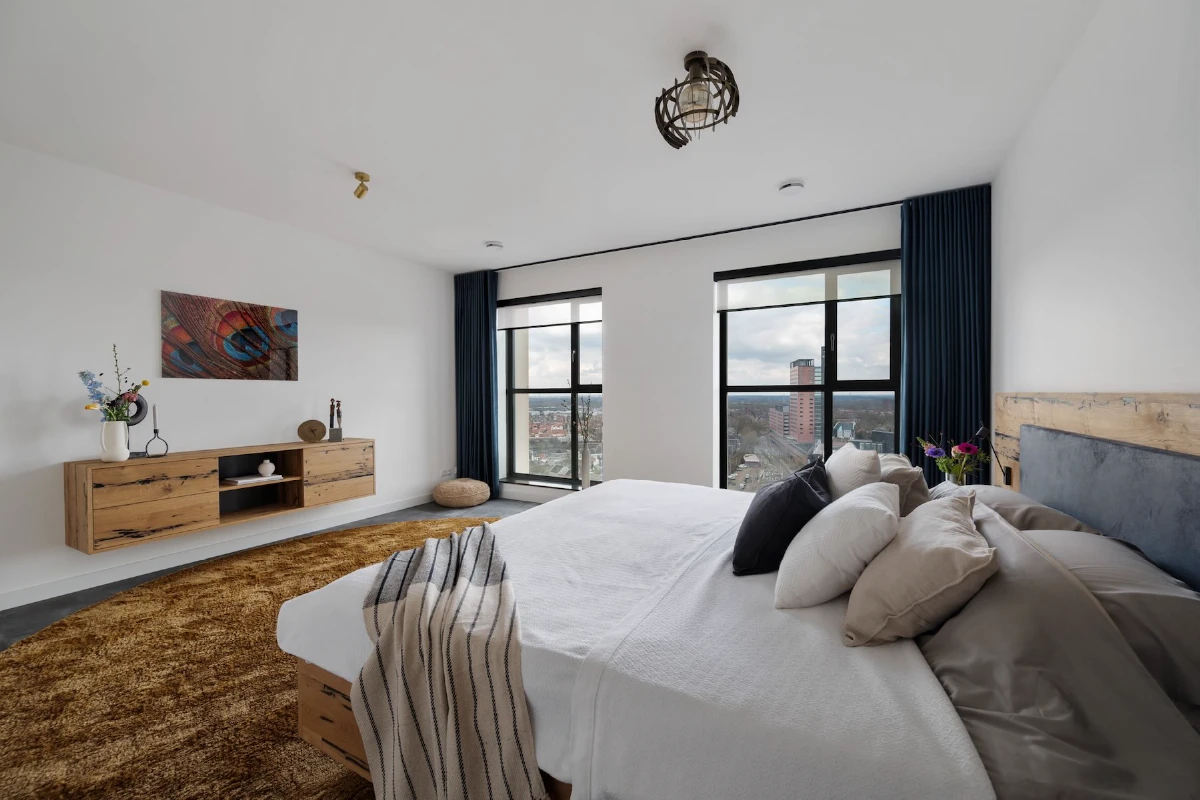 Bijpassend houten dressoir naast het bed