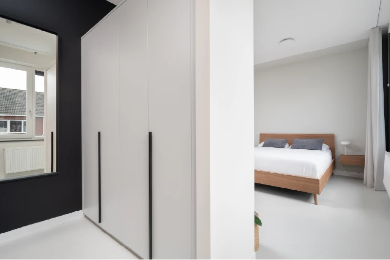 Slaapkamer met houten design bed en inloopkast