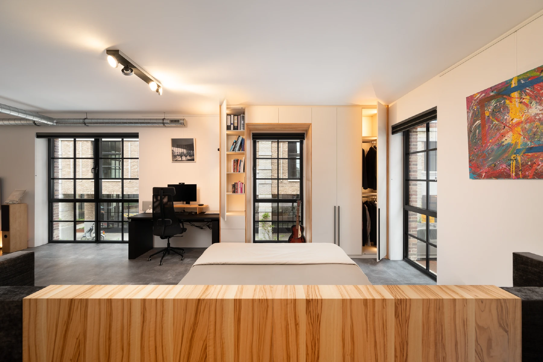 Loft slaapkamer met houten design bed en maatwerkkasten