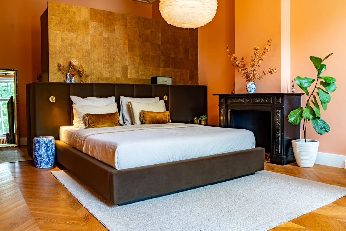 Design bed Formosa tegen de kastenwand, naast de schouw
