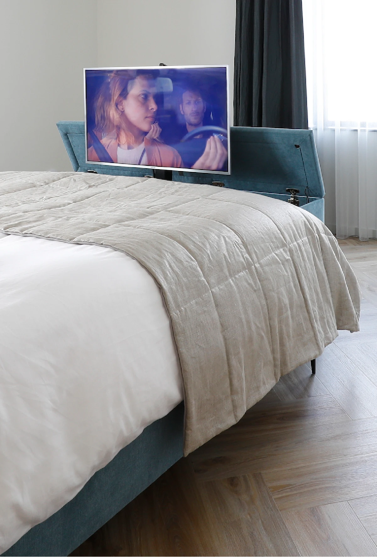 Hocker met tv-lift aan het voeteinde van het bed