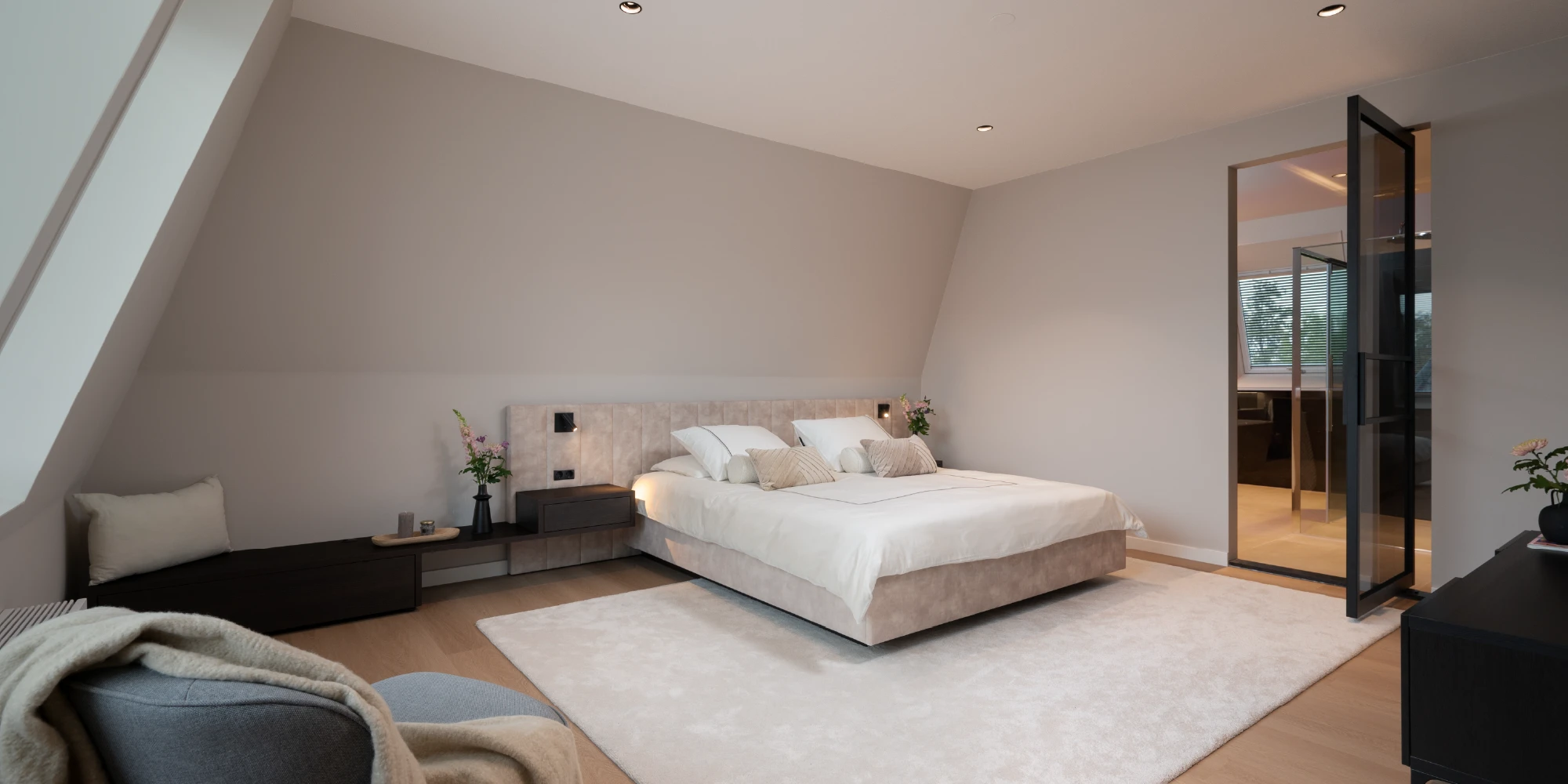 Zolderkamer met bed onder schuin dak overzicht